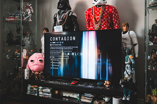 Television showing Contagion, surrounded by Star Wars figures and collectibles