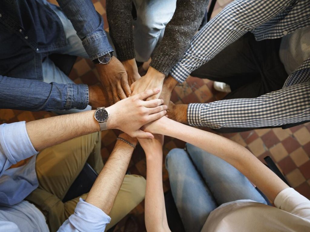 People stacking their hands together in a team huddle.