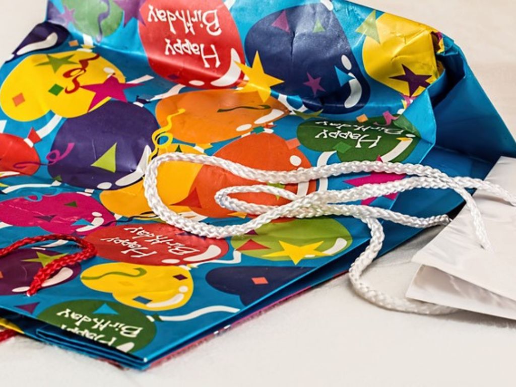 Blue gift bags decorated with balloons, stars and “Happy Birthday” lettering.