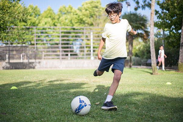 Child kicking a soccer ball on grass