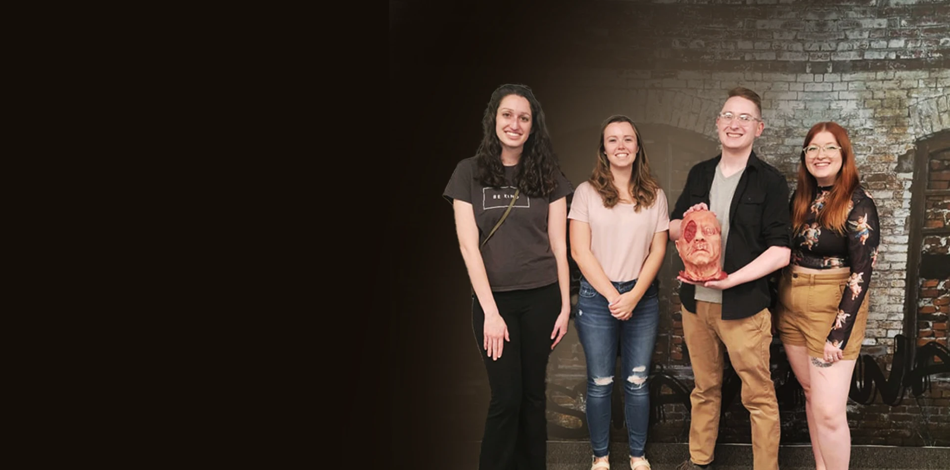 Four players pose together in front of an escape-room backdrop.