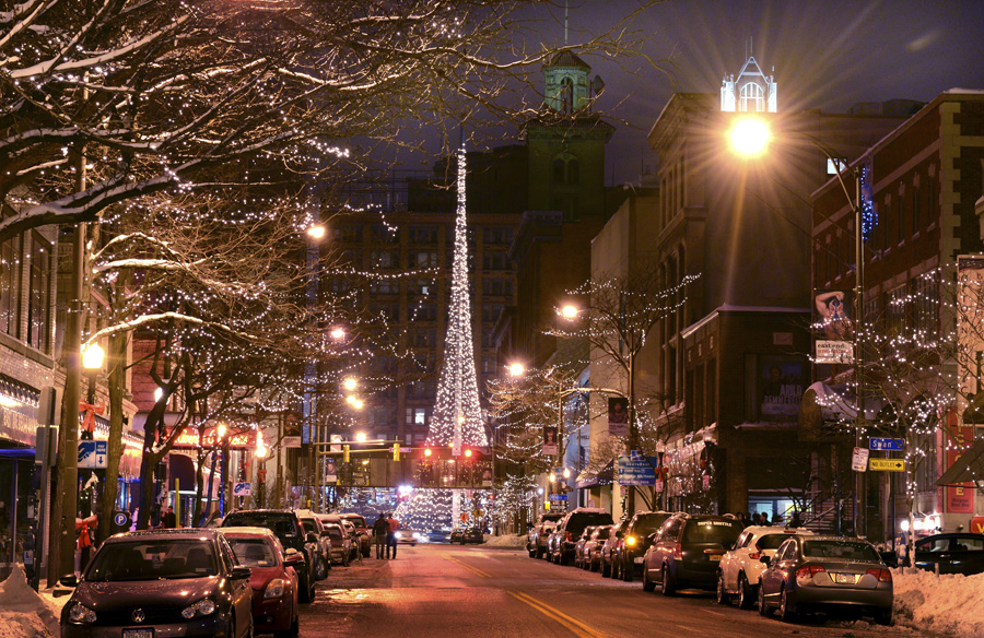 Downtown Rochester street decorated with holiday lights and Christmas tree at night