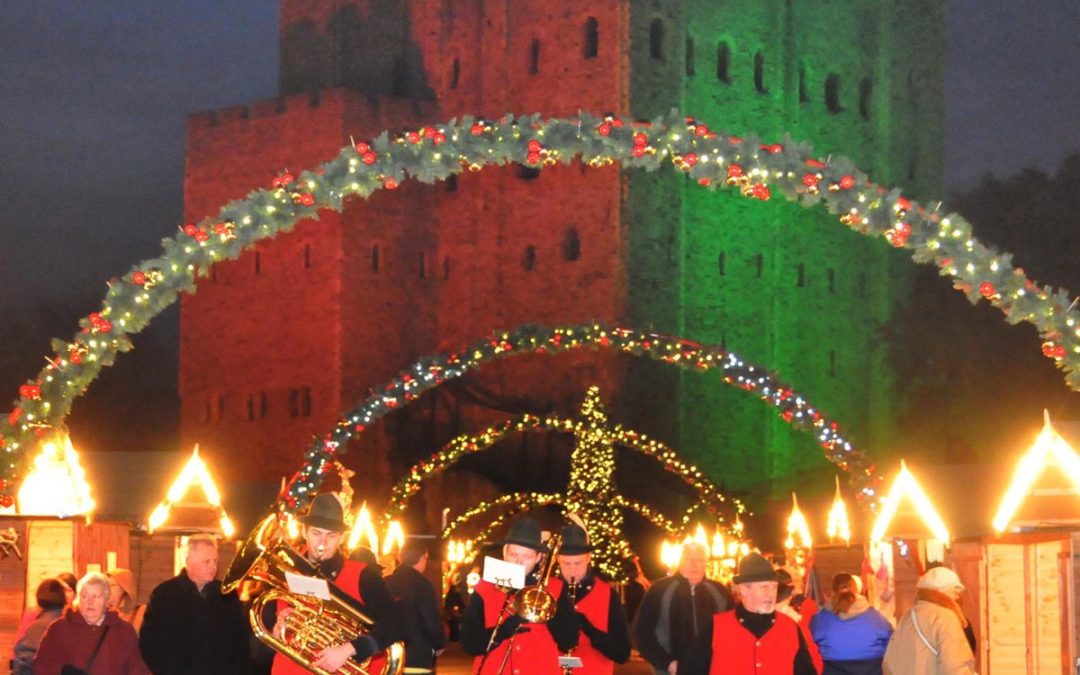 Christmas market with illuminated arches and decorated castle backdrop